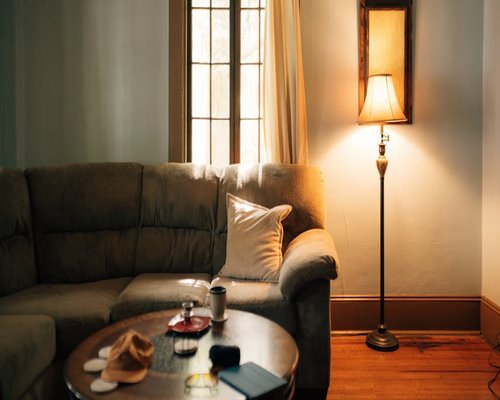 A warm lit living room with a cozy sofa and a modern lamp